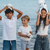 Enfants jouant avec le Lapin Méloé blanc 37 cm Maïlou Tradition à la plage