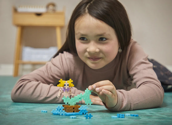 Enfant jouant avec le kit PLUS PLUS PETITE SIRENE