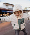 Cagoule enfant Hello Hossy Warmy Cream en polaire douce avec cordons ajustables