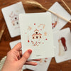 Carte Félicitations Baptême Papier Poetic avec église, ange et illustration poétique aux tons terracotta