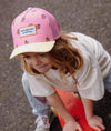 Casquette enfant Hello Hossy Snack rose et jaune pastel avec filet rose et motifs fruits