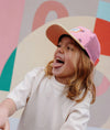 Casquette enfant Hello Hossy Snack rose et jaune pastel avec filet rose et motifs fruits
