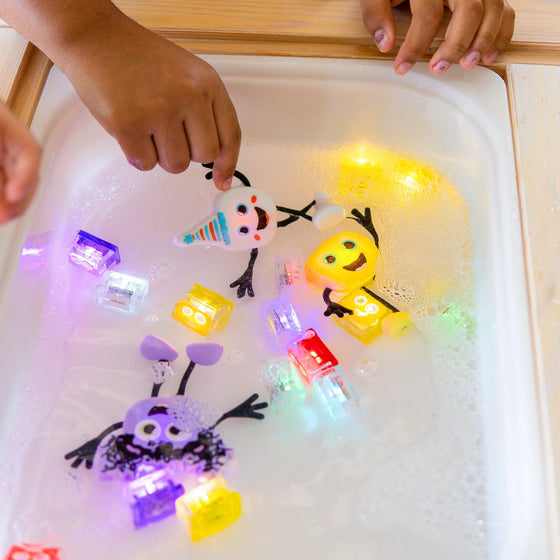 Personnage party blanc et cubes lumineux pour le bain Glo Pals.