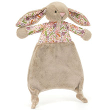  Doudou lapin Jellycat Blossom Beige Petal avec oreilles et haut fleuris, fond beige