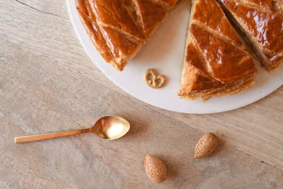 Fève Bretzel Baubels en porcelaine artisanale beige et dorée sur carte Les Jolies Fèves