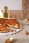Fève Cœur Filant Baubels en porcelaine artisanale avec arc-en-ciel et cœur rose sur carte Les Jolies Fèves