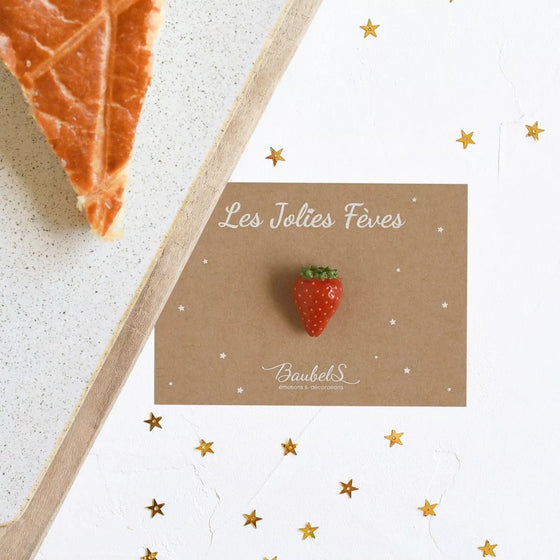 Fève Fraise Baubels en porcelaine artisanale rouge brillante sur carte Les Jolies Fèves