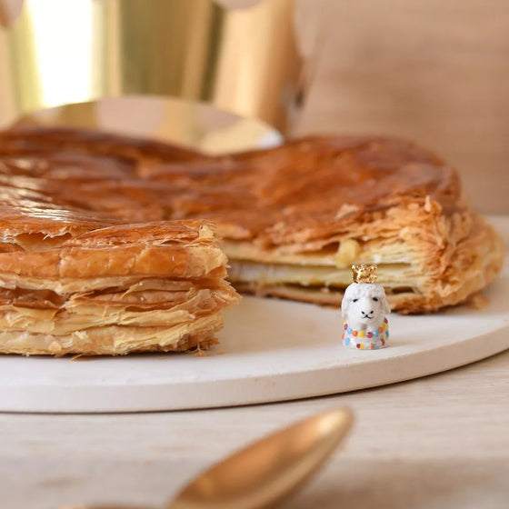 Fève Lama Baubels en porcelaine artisanale avec couronne dorée sur carte Les Jolies Fèves