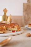 Fève Pastèque Baubels en porcelaine artisanale en forme de tranche de pastèque sur carte Les Jolies Fèves