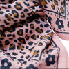 Femme élégante portant un foulard rose imprimé léopard – accessoire mode femme chic