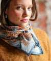 Foulard coton imprimé fleurs bleu et brique porté en écharpe femme Pia Brique Bëllemme.