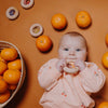 Hochet sensoriel en bois Petit Boum Donut Oranges avec perles et tranches d’orange