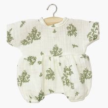  Barboteuse "Noa" en gaze de coton pour poupée Babies de Minikane, coloris écru avec imprimé feuillage vert. Modèle à manches courtes et coupe bouffante avec élastiques aux jambes pour un style délicat et confortable. Accessoire idéal pour habiller un poupon avec élégance.