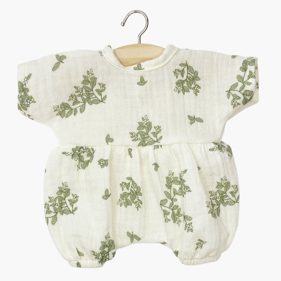 Barboteuse "Noa" en gaze de coton pour poupée Babies de Minikane, coloris écru avec imprimé feuillage vert. Modèle à manches courtes et coupe bouffante avec élastiques aux jambes pour un style délicat et confortable. Accessoire idéal pour habiller un poupon avec élégance.