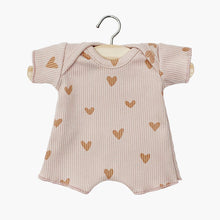  Body shorty en maille côtelée pour poupée Babies de Minikane, coloris rose poudré avec imprimé petits cœurs. Modèle à manches courtes et encolure américaine pour un habillage facile. Accessoire doux et confortable, parfait pour compléter la garde-robe d’un poupon.