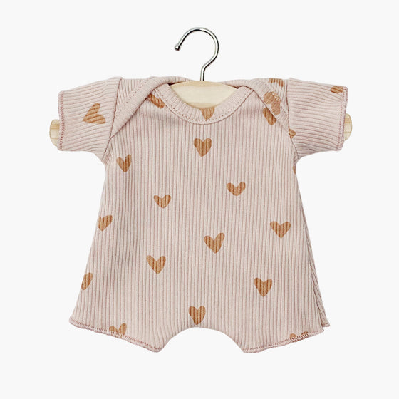 Body shorty en maille côtelée pour poupée Babies de Minikane, coloris rose poudré avec imprimé petits cœurs. Modèle à manches courtes et encolure américaine pour un habillage facile. Accessoire doux et confortable, parfait pour compléter la garde-robe d’un poupon.