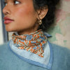Foulard coton imprimé fleurs bleu et brique porté en écharpe femme Pia Brique Bëllemme.