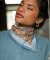Foulard coton imprimé fleurs bleu et brique porté en écharpe femme Pia Brique Bëllemme.
