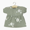 Robe "Faustine" en coton double gaze pour poupée Babies de Minikane, imprimé floral délicat sur fond écru. Modèle à manches courtes bouffantes et coupe évasée, conçu pour habiller un poupon avec élégance. Accessoire idéal pour enrichir la garde-robe des poupées.