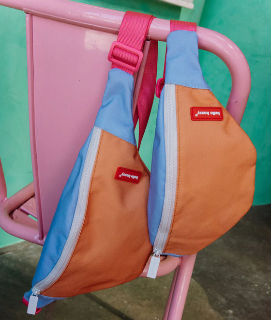 Sac banane enfant Hello Hossy Mini Indiana avec couleurs orange, bleu ciel et rose, fermeture blanche, ceinture réglable rose