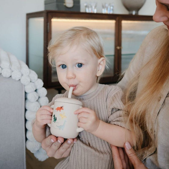 Tasse à paille Mushie Dino en silicone avec poignées et motifs dinosaures