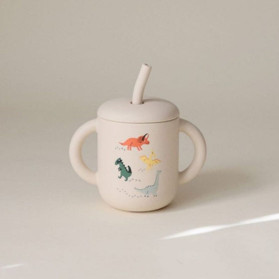 Tasse à paille Mushie Dino en silicone avec poignées et motifs dinosaures